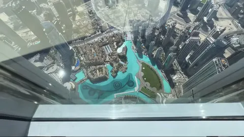 Looking straight down from Burj Khalifa onto the turquoise Dubai Fountain lagoon