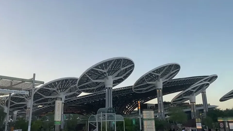 Terra Sustainability Pavilion exterior with giant solar canopies at dusk