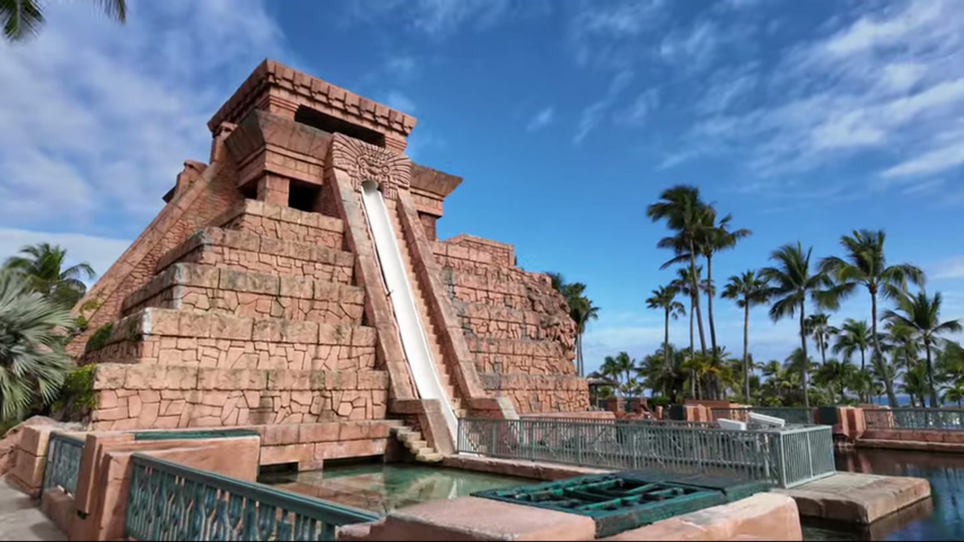 A tall Mayan temple replica with a water slide going down the middle.