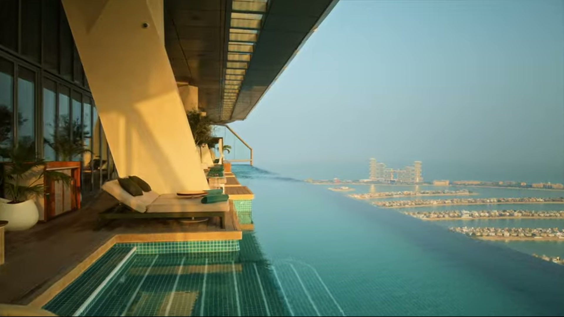 Golden-hour pool deck at Aura Skypool overlooking Palm Jumeirah