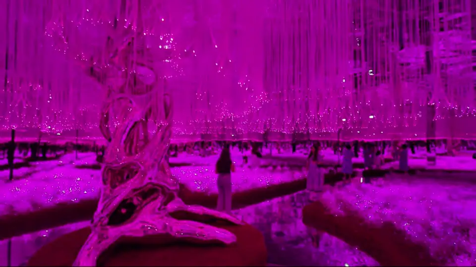 Silver sculpture stands inside a pink fiber-optic garden.