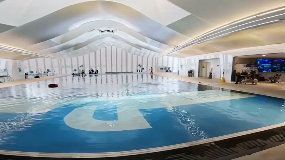 Светлый бассейн с подводным логотипом Deep Dive Dubai и зоной контроля.