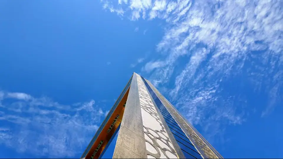 Dubai Frame towers above palm trees under bright blue sky.