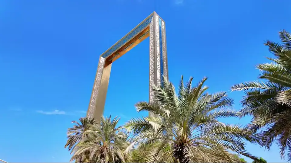 Dubai Frame at night with crowd and red drone message.