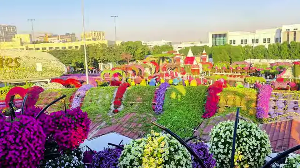 Elevated panoramic view of arches, towers, and patterned flower beds.