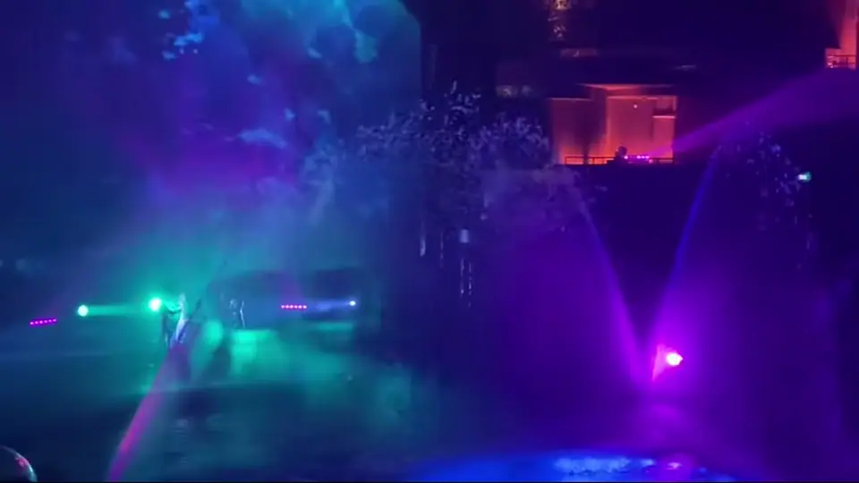 Fire and purple fountains illuminate the aquatic theater auditorium.