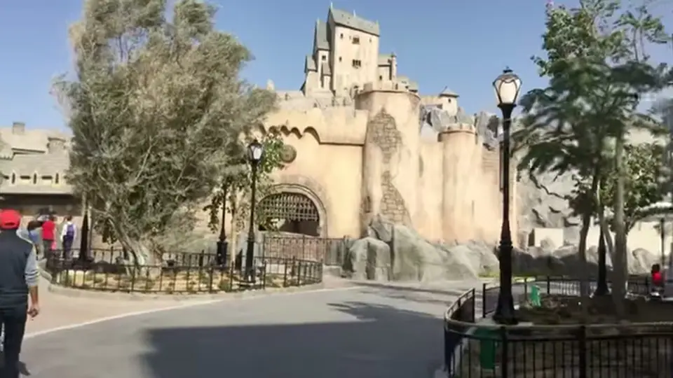 Hotel Transylvania castle facade with towers and a curving road.