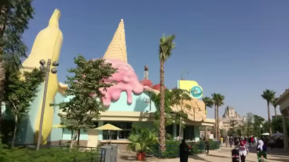 Pastel building with giant ice cream decor and surrounding palms.