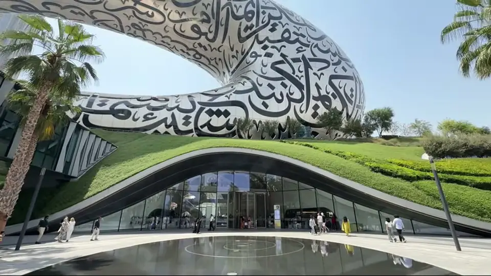 Wide view of the main hall with staircase, crowd, and glowing walls.